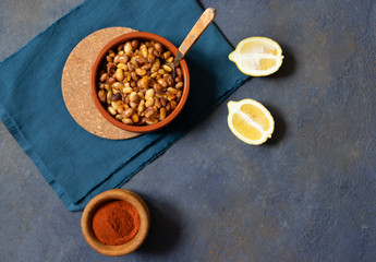 Prebranac Balkan baked beans. Serbian, Montenegrin, Bosnian, Croatian and Slovenian cuisine. Baked  beans, lemon, paprika powder. Dark background. Top view. Space for text