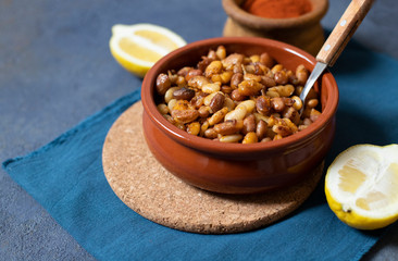 Prebranac Balkan baked beans. Serbian, Montenegrin, Bosnian, Croatian, Slovenian cuisine. Baked  beans, lemon, paprika powder. Dark background. Close up. Space for text