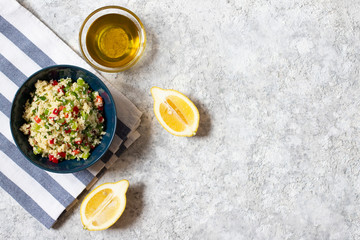 Tabbouleh salad with couscous, parsley, lemon, tomato, olive oil. Levantine vegetarian salad. Lebanese, arabic cuisine. Light background. Top view. Space for text