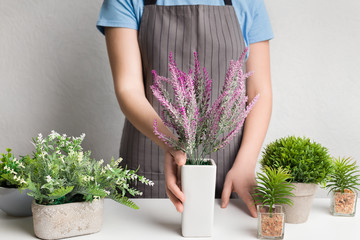 Designer in apron putting lavender plant on table