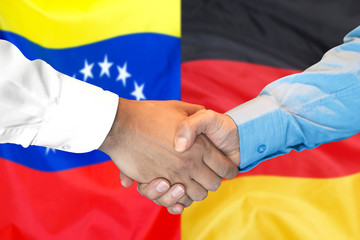 Handshake on Venezuela and Germany flag background.