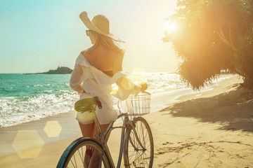 Happiness woman traveler with her bicycle rides on sea coastline