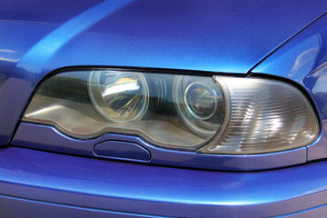 Part of a blue car. Car headlights. Luxury Headlights