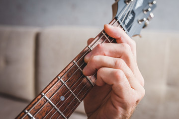 Fm chord - close-up male Caucasian hand takes a chord on a 6 string guitar