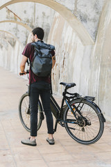 Back view of a man standing next to e-bike