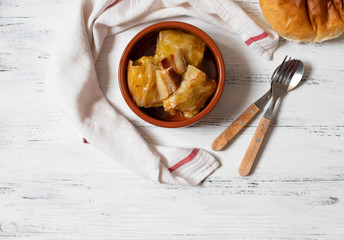 Sarma - traditional dish of Balkan cuisine. Cabbage rolls with meat and rice. Balkan cuisine. Serbian cuisine. Light wooden background. Top view. Space for text