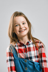 portrait of a happy child. little girl smiles and shows emotion. studio fashion kid shooting.