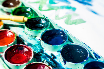 Sheet of paper and old watercolor paints