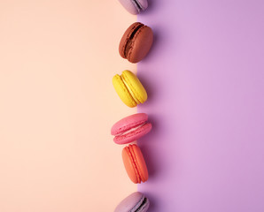 multi-colored macarons with cream on a purple-beige background