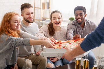 Happy friends taking slices of hot pizza from box