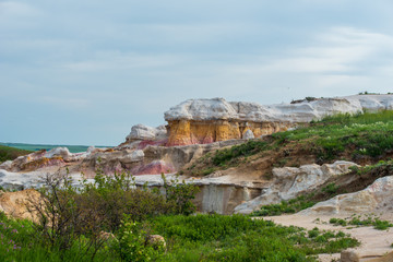 Fototapeta na wymiar Landscape of pink, yellow and white stone formations against a cloudy sky at Interpretive Paint Mines in Colorado