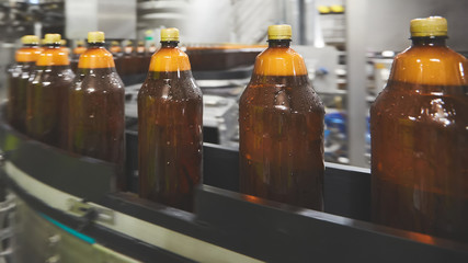 Plastic bottles for beer or carbonated beverage moving on conveyor. Shallow DOF. Selective focus.