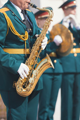 A wind instrument parade - a man in green costume playing saxophone