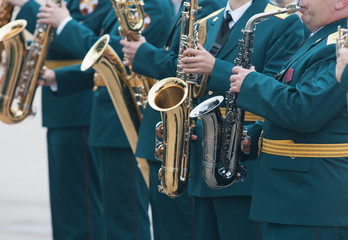 A wind instrument parade - people in green costumes playing saxophone