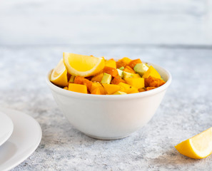 Pegan salad with mango, avocado and sweet potatoes, served with lemon water. Paleo diet. Pegan diet. Vegetarian food. Light background