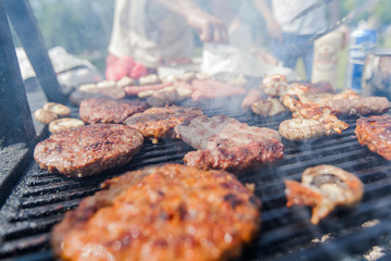 Grilled burger and chicken meat on barbecue at picnic