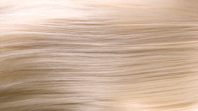 Hair. Beautiful healthy long straight blonde hair closeup texture. Dyed wavy white blond hair background, coloring, extensions, cure, concept. Haircare. Slow motion 4K UHD video footage. 3840X2160