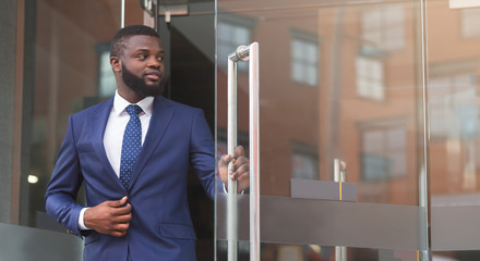 Handsome african american ceo leaving business center after meeting