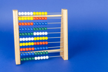 A slide rule with colorful balls, blue background and copy space