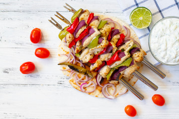 Traditional Greek grilled chicken Souvlaki with Tzatziki sauce and Pita Bread. Light background. Top view