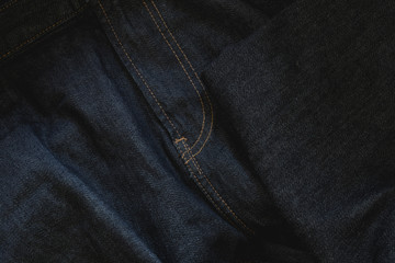 Dark blue jeans background with detailed sewing - Wavy denim textured fabric with zipper seam in detail