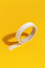 Roll of paper stationery tape on a yellow background