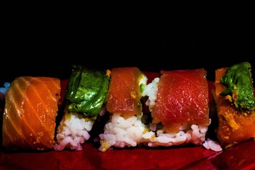 sushi on red plate with black background