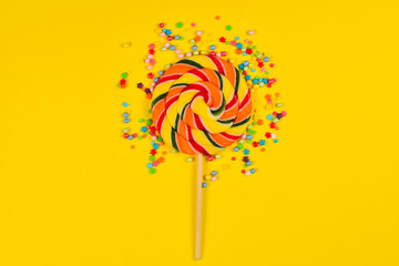 Colorful candy on a yellow  background. Lollipop. Top view. Copy space.