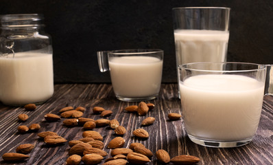 Almond healthy organic vegan milk. Dark wooden background. Close-up view. Toned photo