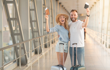 Tourism and vacation concept. Happy couple with passports and air tickets
