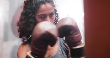 Closeup female boxer punching a punch bag