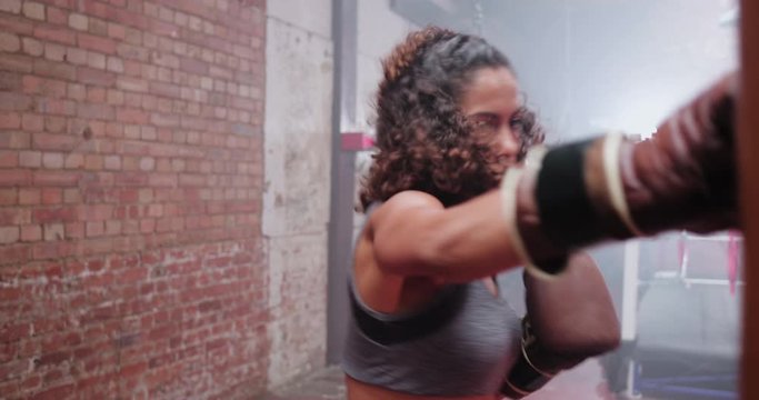Female boxer punching a punch bag