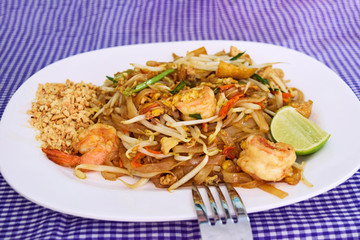 Rice noodles with shrimp and vegetables close-up on the table.