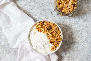 Bowl of Homemade granola with Greek yogurt on a light background. Ingredients for a healthy breakfast. Top view
