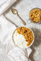 Bowl of Homemade granola with Greek yogurt on a light background. Ingredients for a healthy breakfast. Top view