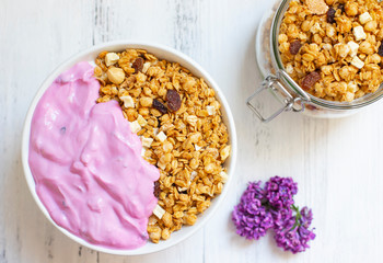 Bowl of Homemade granola with Blueberry Greek yogurt on a light background. Ingredients for a healthy breakfast. Top view