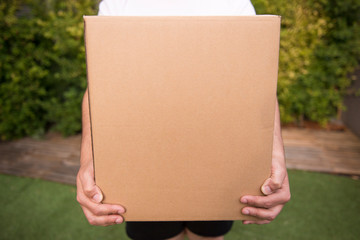 Man Holds Carton Box In Hands, shipping delivery box in hands, carton package. Parcel delivery with good depth of field.