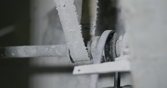 Detail of the mechanism of a old mill. Weel spinning connected to a belt