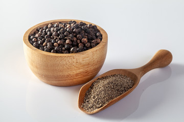 Black pepper and pepper grinder on a white background