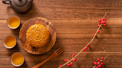 Chinese traditional pastry Moon cake Mooncake with tea cups on bamboo serving tray on wooden background for Mid-Autumn Festival, top view, flat lay.