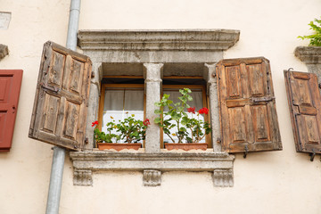 Old stone window with flowerboxes with flowers.