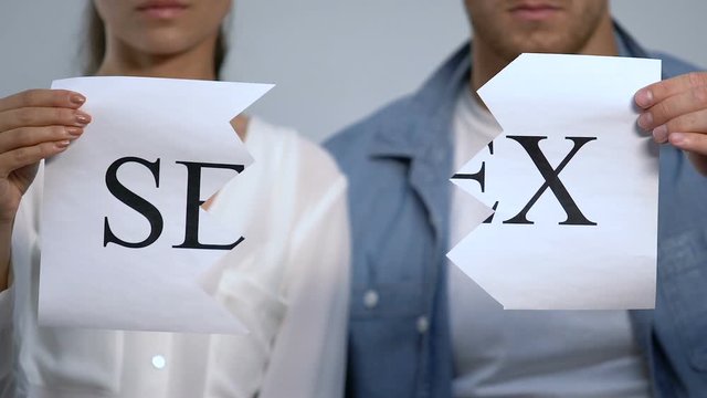 Woman and man tearing sex sign on pieces, intimacy and sexual relations problem