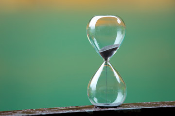 Hourglass on wooden and colorful background