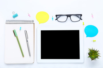 Tablet computer with office supplies on white background