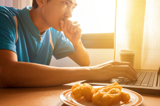 A man is working with laptop on the wooden desk at the office and drinking a cup of espresso coffee for refresh the brain. He is freelance, work at home with wireless network to communicate with team.