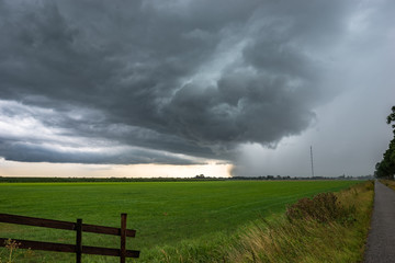 Fototapeta na wymiar Strong thunderstorm with hail shaft over the green dutch countryside