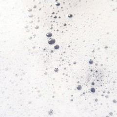White foam with bubbles popping close up