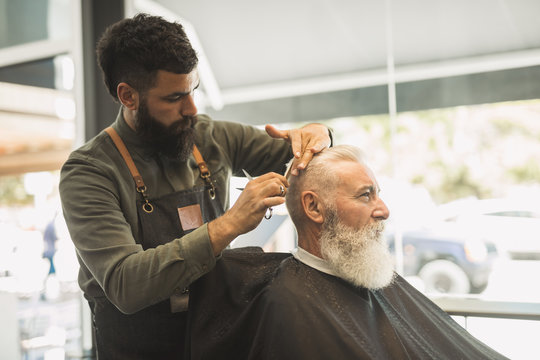 Barber cutting client in barber shop