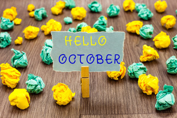 Text sign showing Hello October. Conceptual photo Last Quarter Tenth Month 30days Season Greeting Clothespin holding gray note paper crumpled papers several tries mistakes