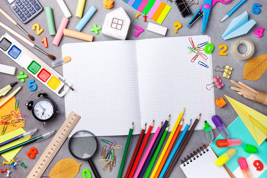 Set of school supplies and stationery with open notebook on gray table top view. Education, learning and back to school concept.